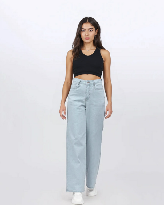 Woman wearing a black tank top and light blue jeans on a white background