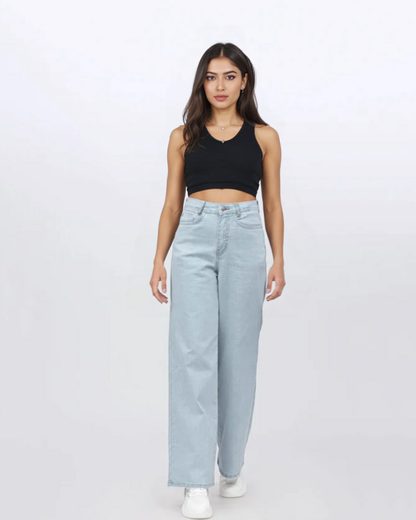 Woman wearing a black tank top and light blue jeans on a white background