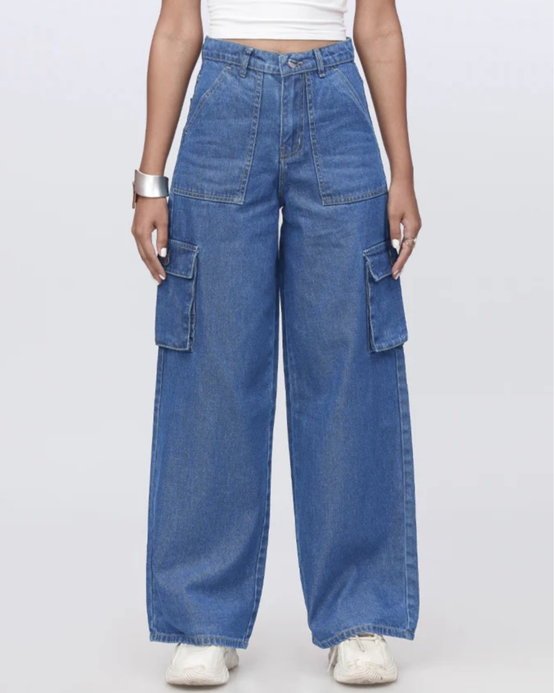 Woman wearing blue jeans and a black top on a white background