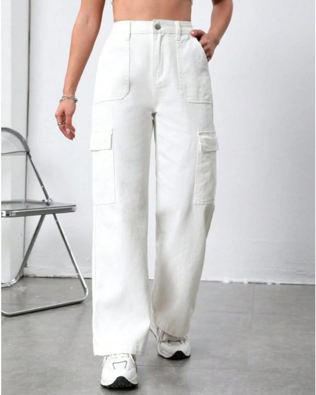 Person wearing white cargo pants with a minimal background